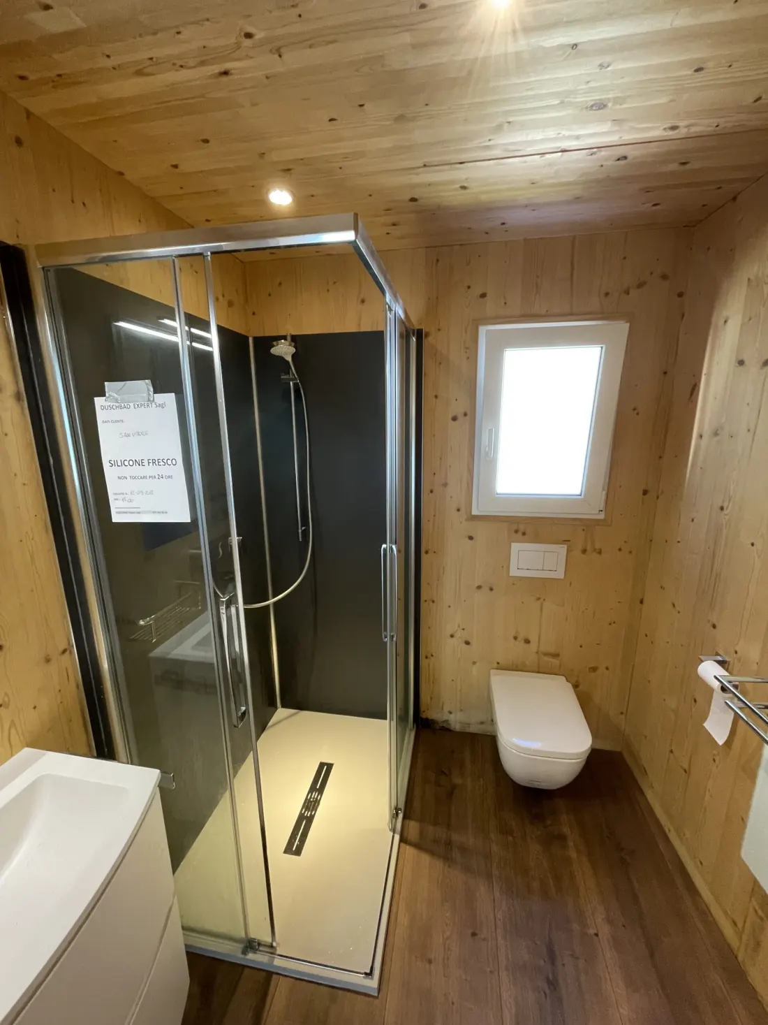 S. Vittore: cabina doccia in vetro montata nel bagno rivestito in legno